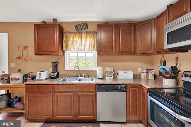 kitchen with light tile patterned floors, sink, and appliances with stainless steel finishes