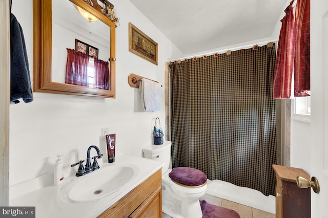 bathroom with tile patterned floors, walk in shower, vanity, and toilet