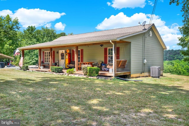 back of property featuring a yard and central AC