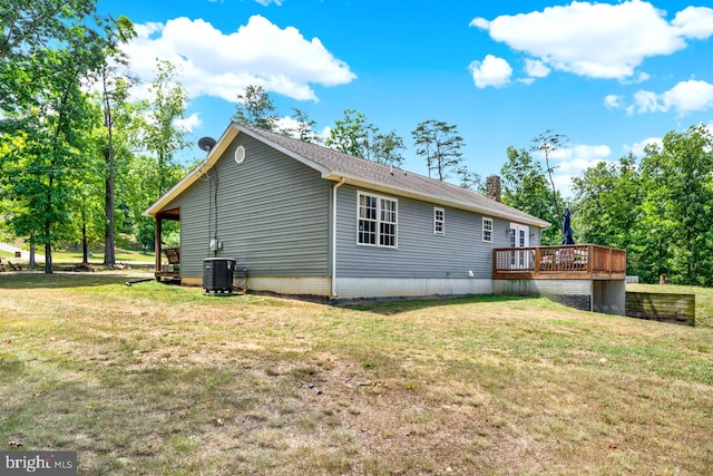 view of side of property with central air condition unit, a yard, and a wooden deck