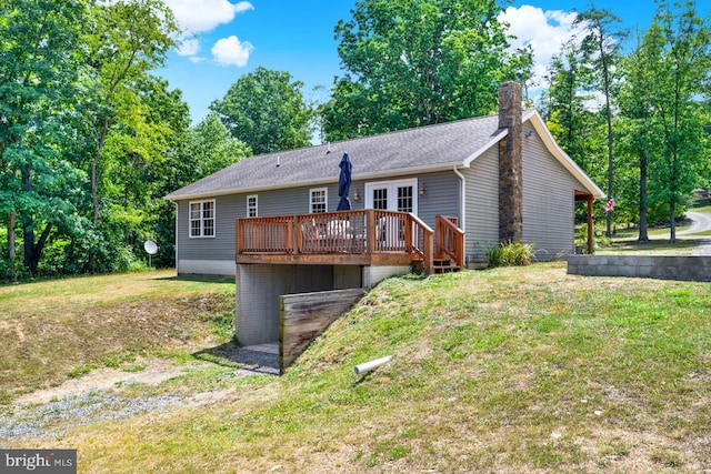 back of property with a lawn, a wooden deck, and french doors