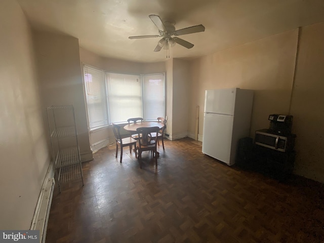 dining space featuring dark parquet floors and ceiling fan