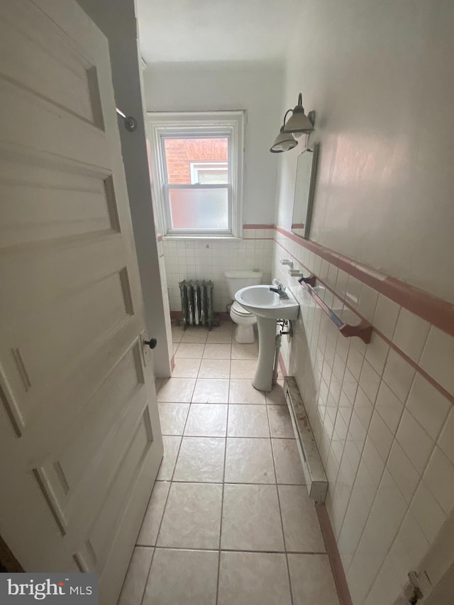 bathroom with tile patterned floors, sink, tile walls, and toilet