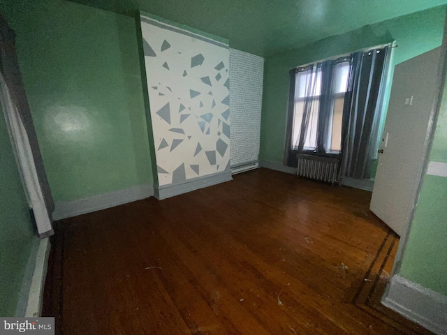 unfurnished room with hardwood / wood-style floors and radiator