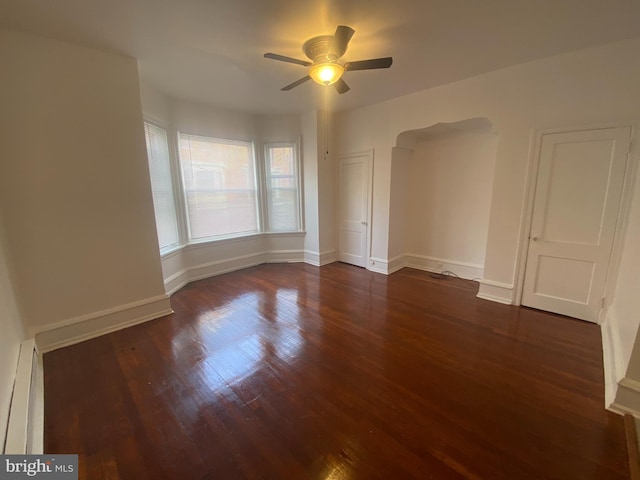 unfurnished room with ceiling fan, dark hardwood / wood-style floors, and a baseboard radiator