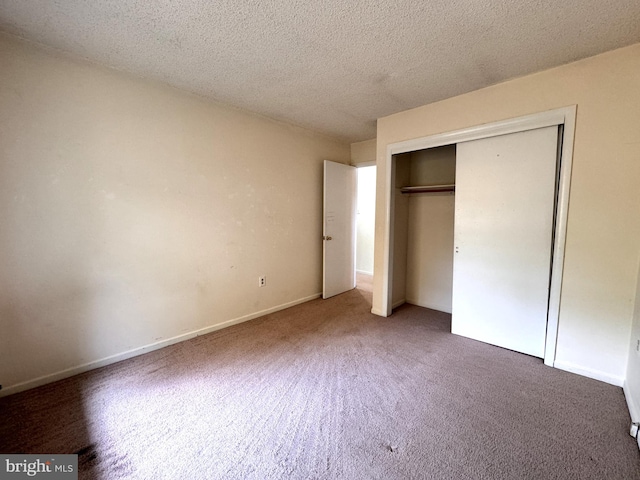 unfurnished bedroom featuring a closet, dark carpet, and a textured ceiling