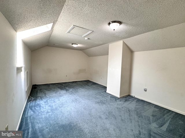 bonus room with dark carpet, lofted ceiling, and a textured ceiling