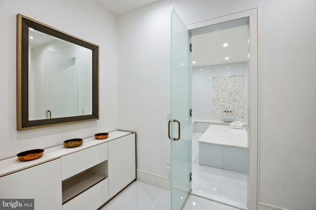 bathroom with tile patterned flooring, vanity, and a shower with door