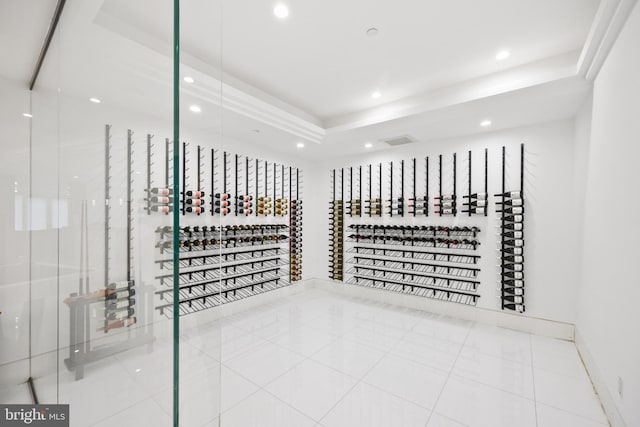 wine room featuring tile patterned flooring and a tray ceiling