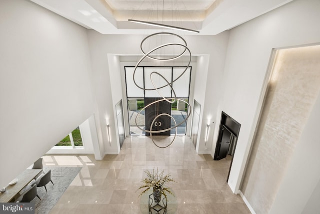 foyer with a tray ceiling and a towering ceiling