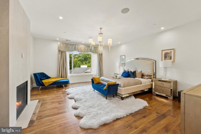 bedroom with light wood-type flooring and an inviting chandelier