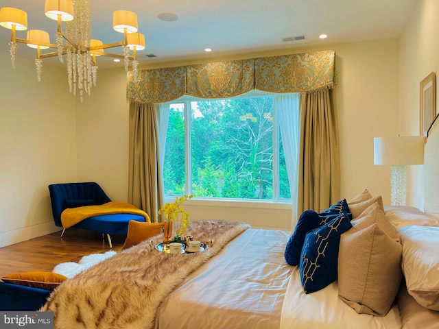 bedroom with hardwood / wood-style floors, multiple windows, and a notable chandelier