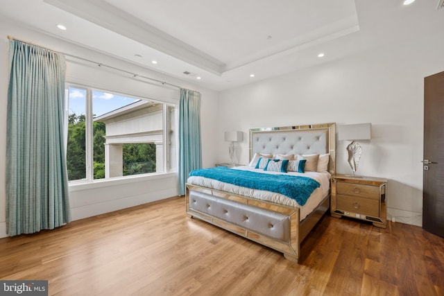 bedroom featuring a tray ceiling and hardwood / wood-style flooring