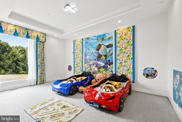 carpeted bedroom with a tray ceiling