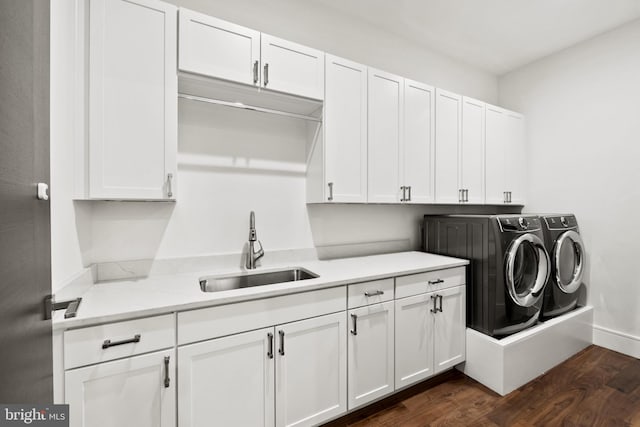 washroom with cabinets, washer and clothes dryer, dark wood-type flooring, and sink