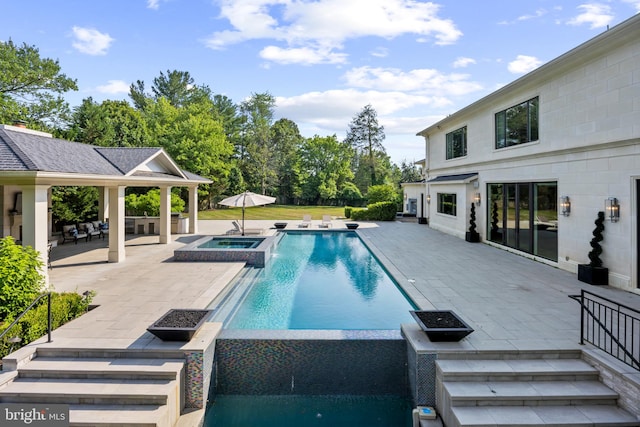 view of swimming pool featuring a patio area and an in ground hot tub