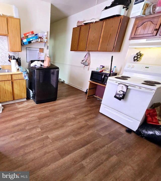 kitchen featuring dark hardwood / wood-style flooring, white range oven, sink, and washer / clothes dryer