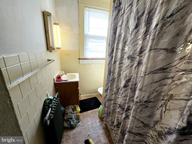 bathroom with radiator, toilet, vanity, tile walls, and a shower with shower curtain