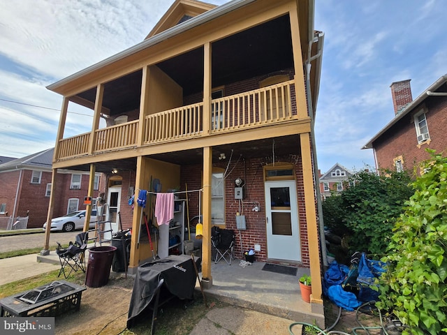 view of front of property featuring a fire pit and a balcony