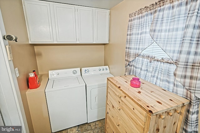 laundry area featuring washer and clothes dryer and cabinets