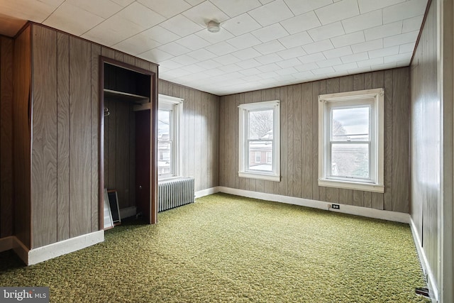 unfurnished bedroom with carpet flooring and radiator heating unit