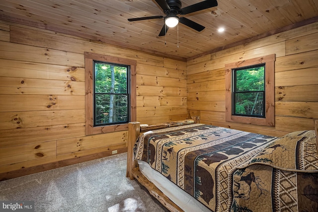 bedroom featuring wooden ceiling, carpet, wooden walls, and ceiling fan