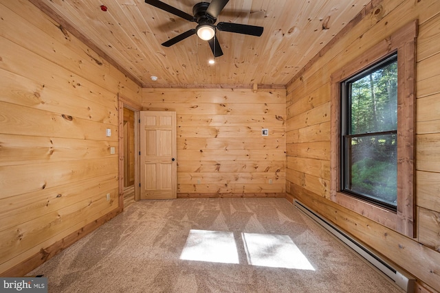 spare room featuring wooden ceiling, baseboard heating, carpet, and wood walls