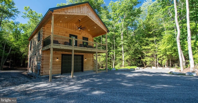 exterior space with a garage and ceiling fan