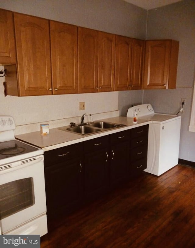 kitchen featuring sink, washer / dryer, white electric stove, and dark wood-type flooring