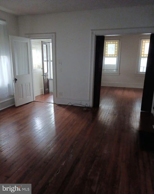 unfurnished room with dark wood-type flooring