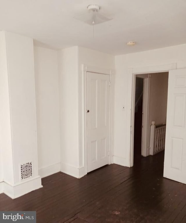 empty room with dark hardwood / wood-style floors and radiator