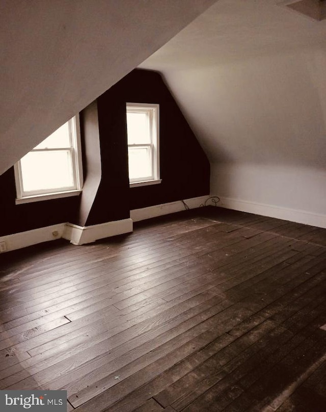 additional living space with dark hardwood / wood-style floors and lofted ceiling