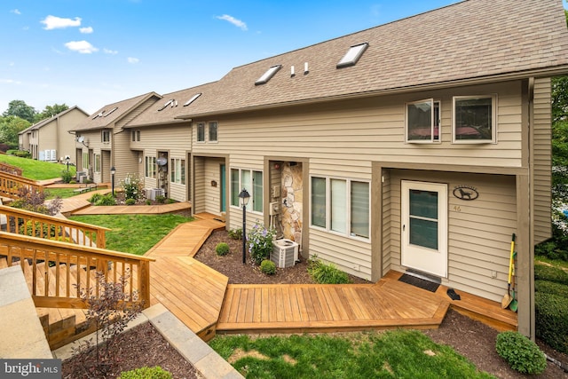 rear view of house featuring a yard and a wooden deck