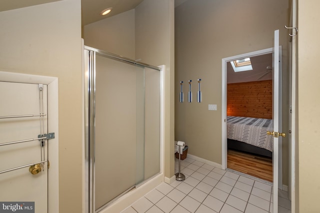 bathroom featuring a skylight, tile patterned flooring, and a shower with door