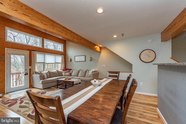 dining area with beamed ceiling and light hardwood / wood-style floors