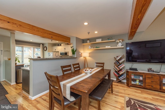 dining area featuring beam ceiling and light wood-type flooring