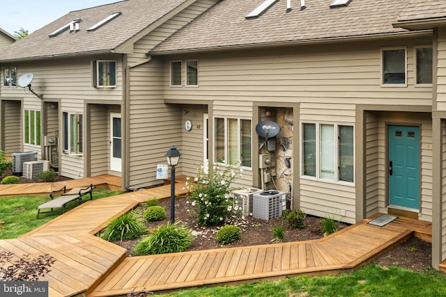 rear view of property featuring a wooden deck and cooling unit