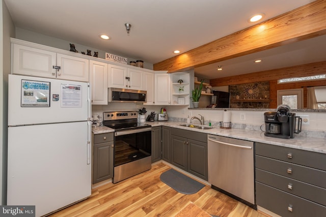 kitchen featuring white cabinets, stainless steel appliances, gray cabinetry, and sink