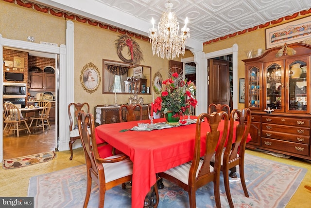 dining area featuring an inviting chandelier and ornate columns