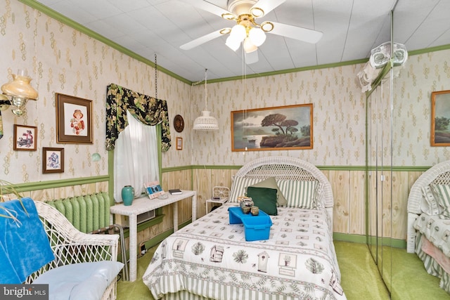 bedroom with ceiling fan, crown molding, and carpet floors