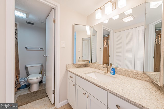 bathroom featuring tile patterned flooring, vanity, and toilet