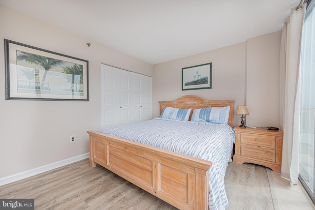 bedroom with light hardwood / wood-style floors and a closet