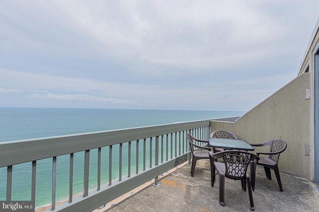 balcony featuring a view of the beach and a water view