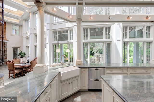 sunroom featuring decorative columns and sink