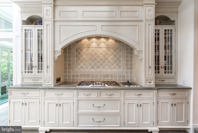 interior space with backsplash and stainless steel gas cooktop