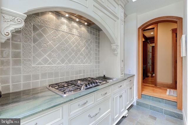 kitchen featuring stainless steel gas stovetop and white cabinetry