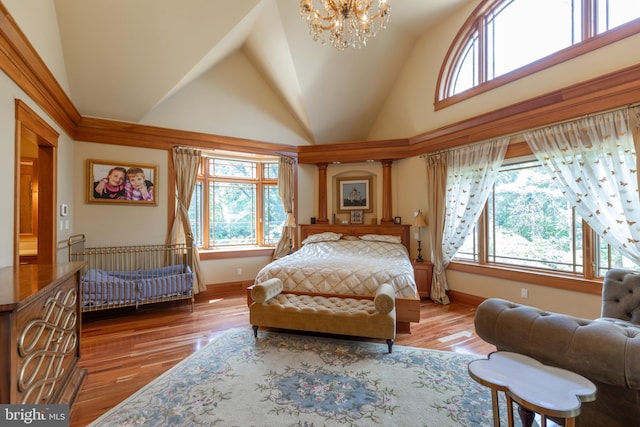 bedroom featuring hardwood / wood-style floors, an inviting chandelier, and multiple windows