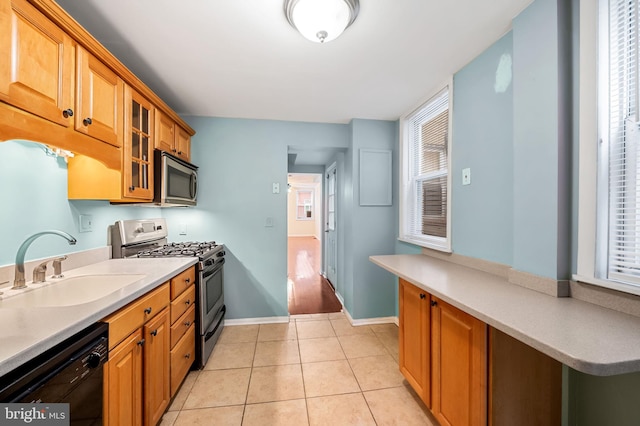 kitchen featuring sink, light tile patterned floors, and stainless steel appliances