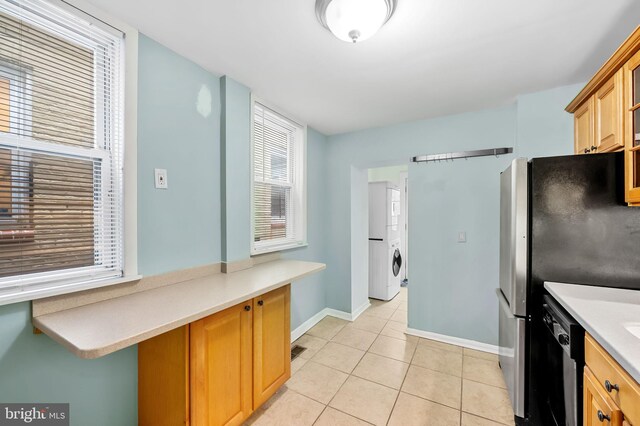 kitchen featuring dishwasher, light tile patterned floors, and stainless steel fridge