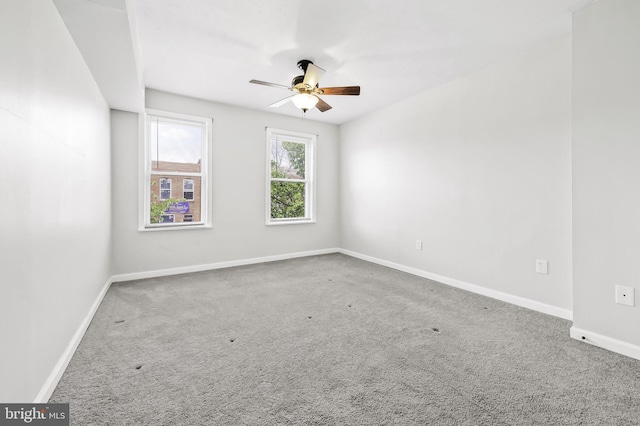 carpeted spare room featuring ceiling fan